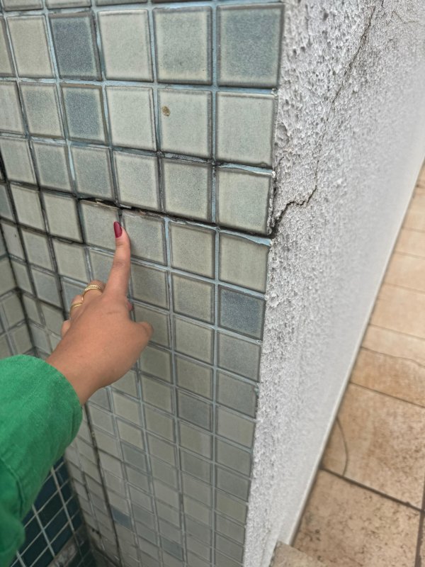 Face frontal da piscina com trinca e desplacamento das pastilhas, analisando a origem e extensão do problema.